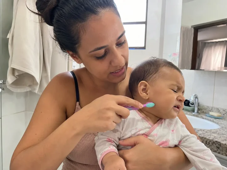 Mãe insegura escovando os dentes do bebê